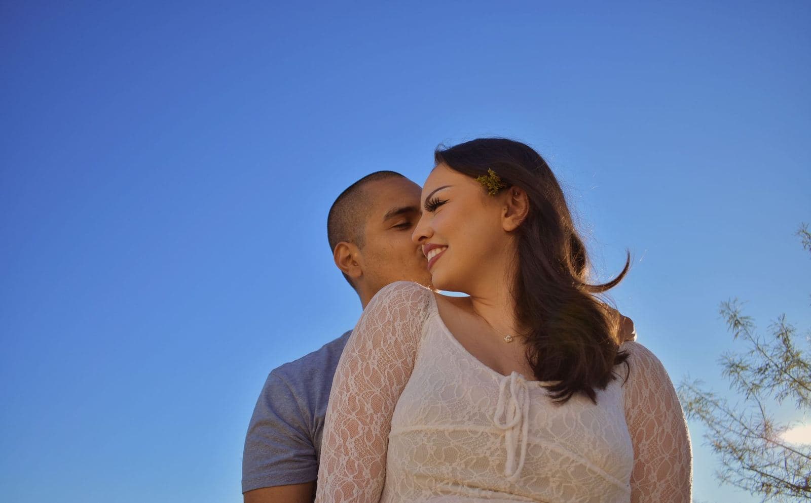 A couple photographed from below against a clear blue desert sky near Las Vegas, NV