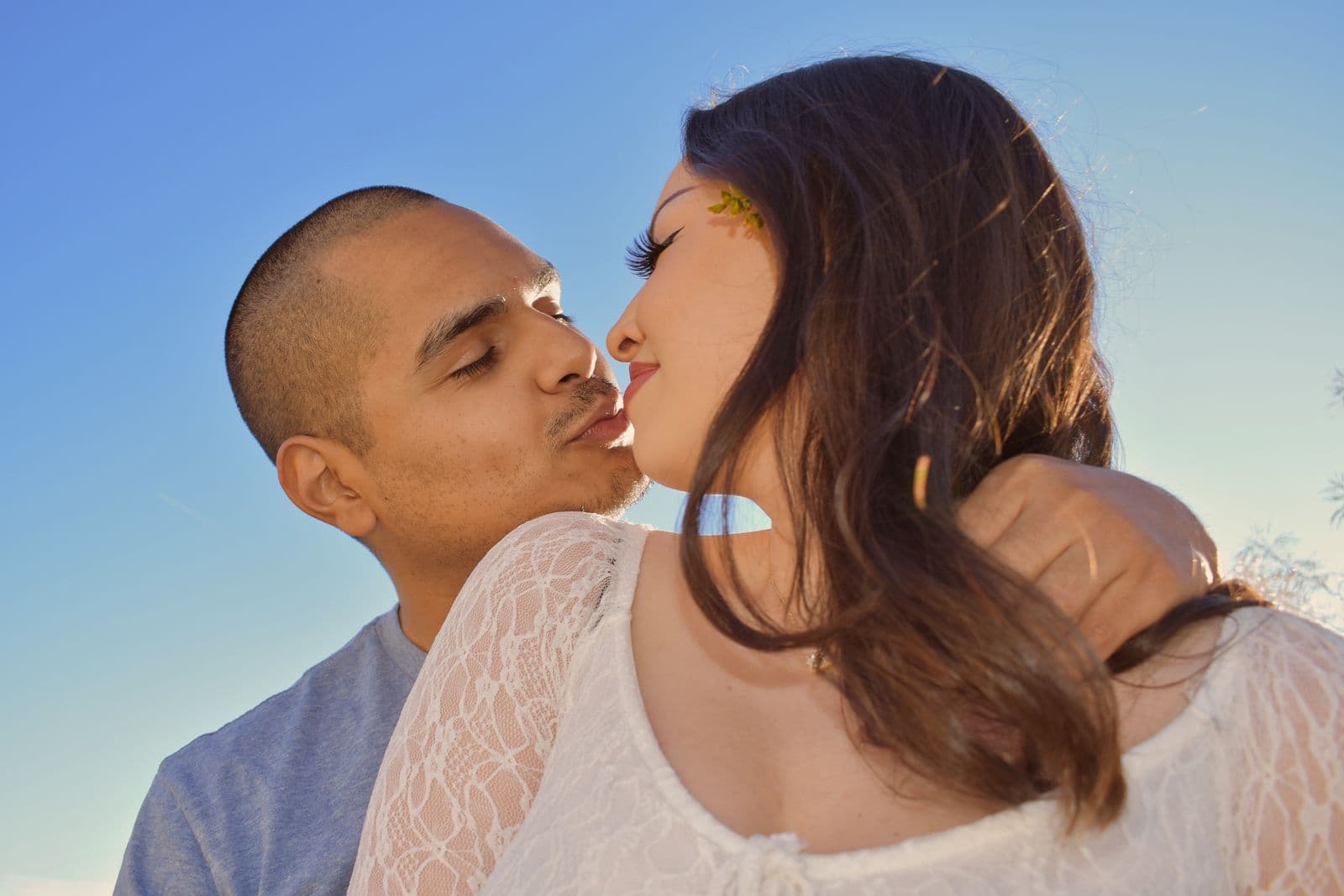A couple kissing against an open blue sky during a desert session near Las Vegas, NV