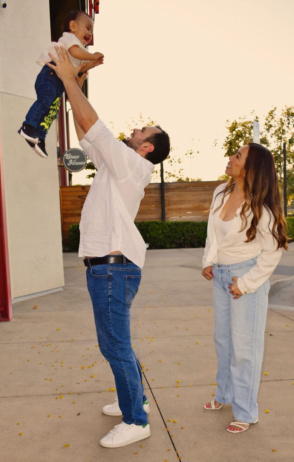 A father lifting his baby overhead as the mother watches and smiles during a session in Las Vegas, NV