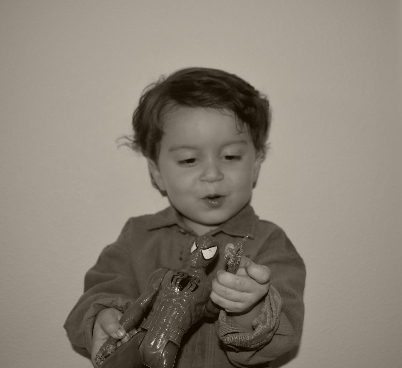 A black-and-white frame of a young boy absorbed in a favorite toy, Las Vegas, NV at-home session