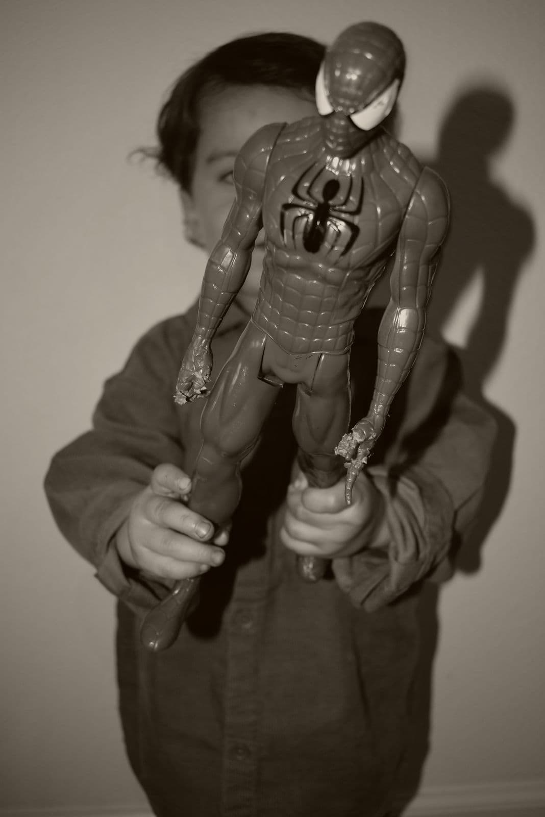 A black-and-white frame of a boy holding up a superhero action figure, Las Vegas, NV family session