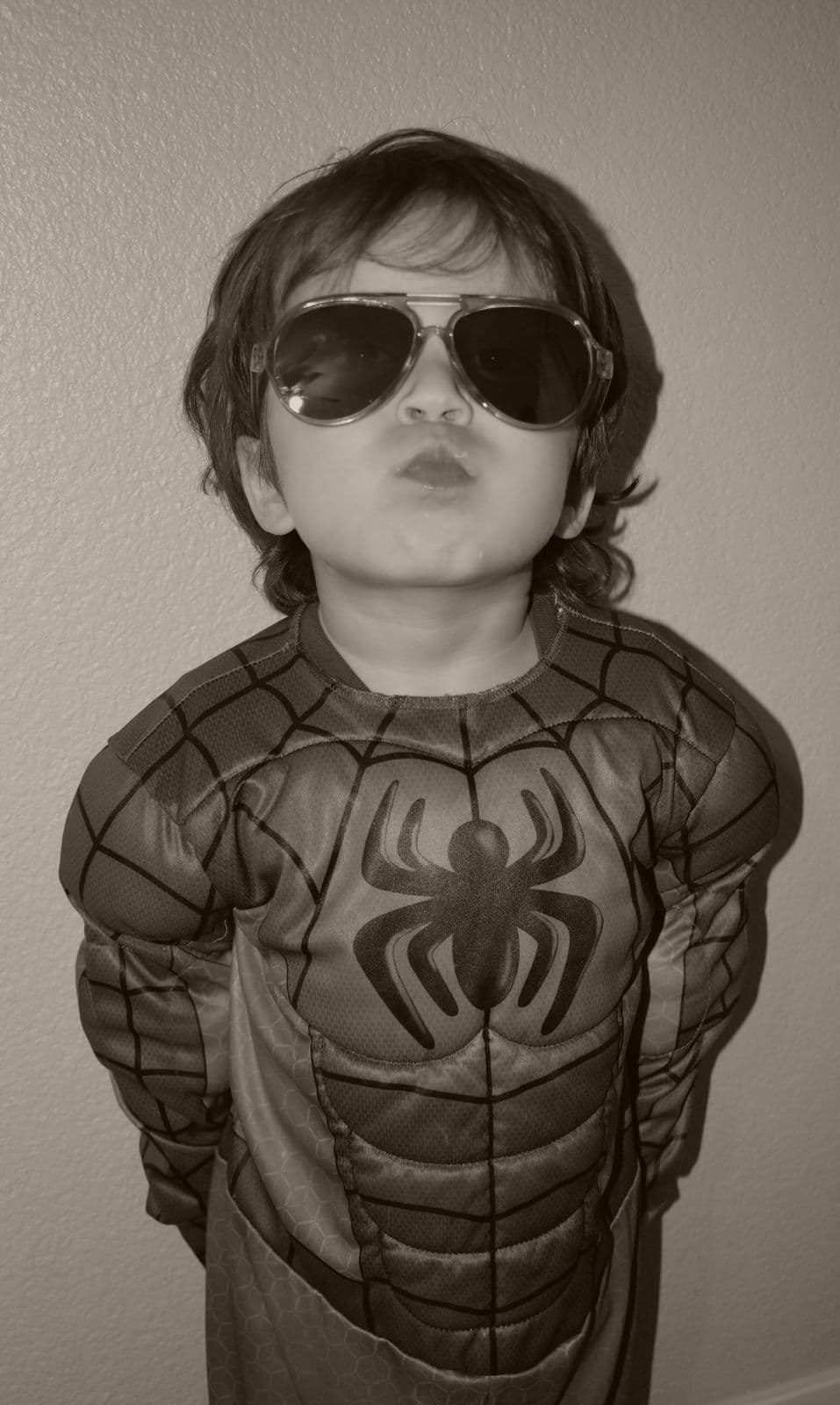 A black-and-white portrait of a young boy in a superhero costume, Las Vegas, NV family session