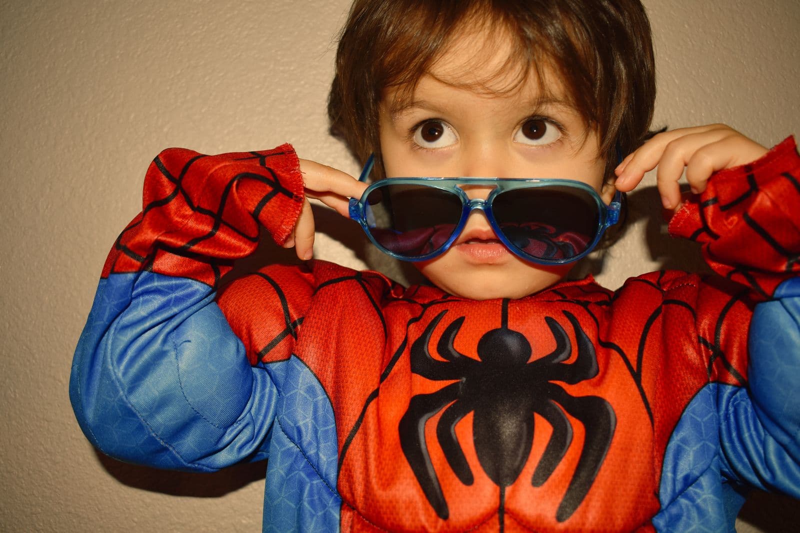 A young boy in a superhero costume wearing oversized sunglasses during a Las Vegas, NV session