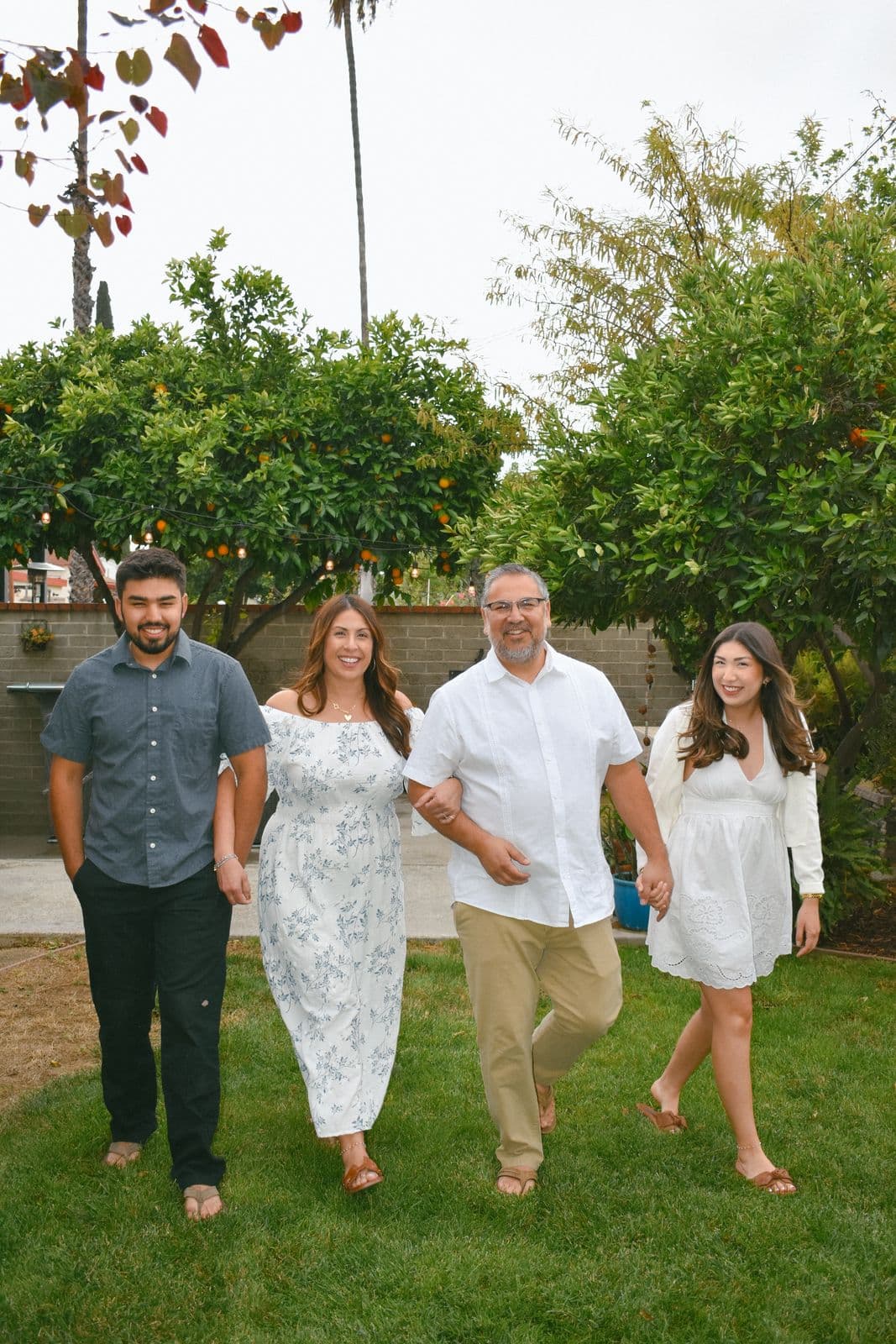 A family of five walking toward the camera across a backyard lawn in Las Vegas, NV
