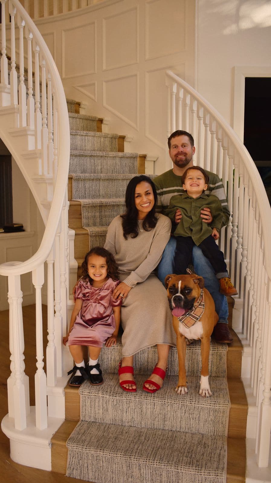 A family of four with their dog photographed on a curved staircase at home in Las Vegas, NV