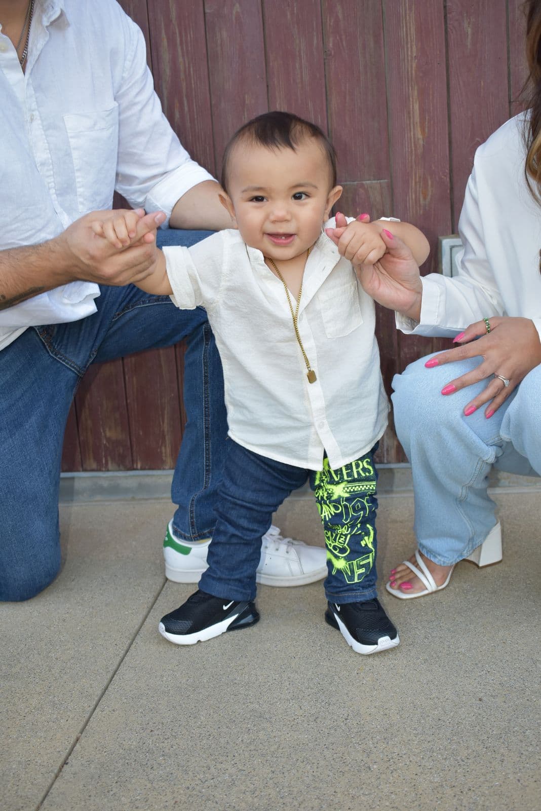 A father helping his toddler son stand and walk during an outdoor session in Las Vegas, NV