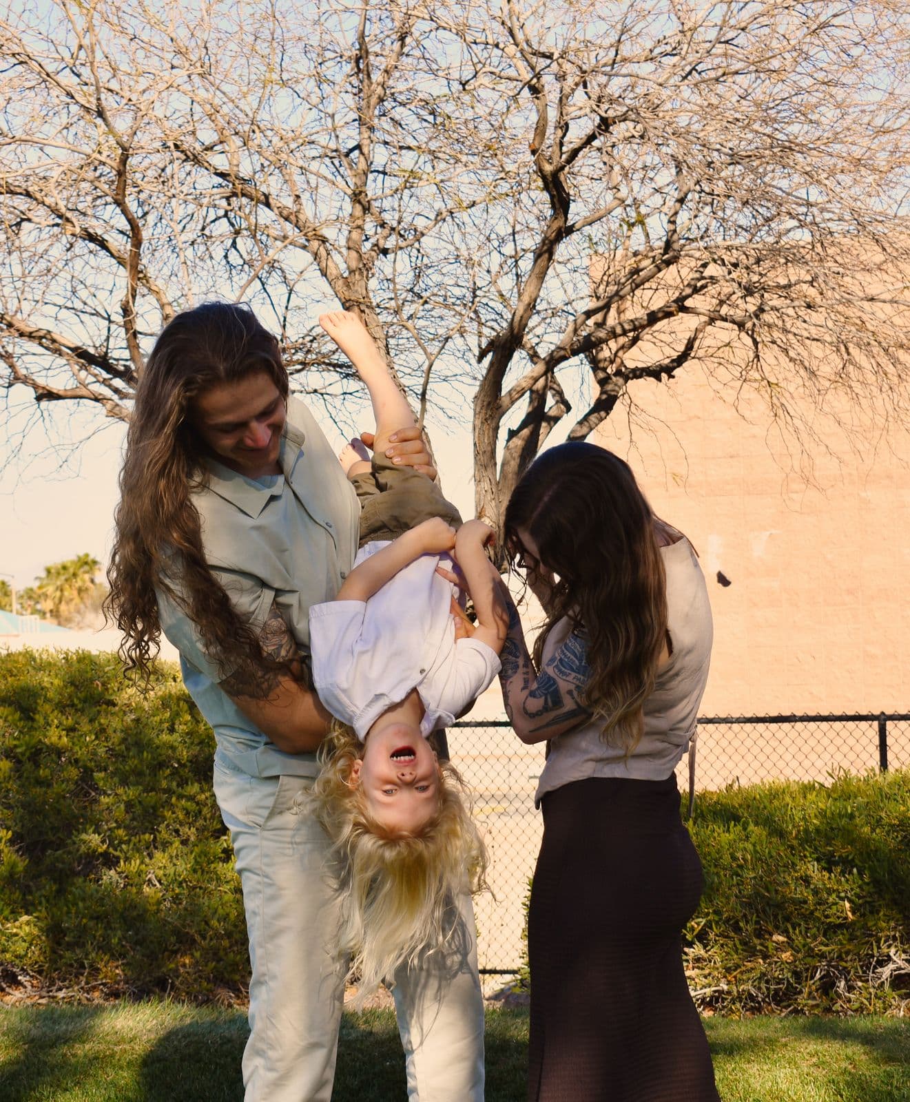 A father holding his laughing toddler upside down while her mother watches, Las Vegas, NV