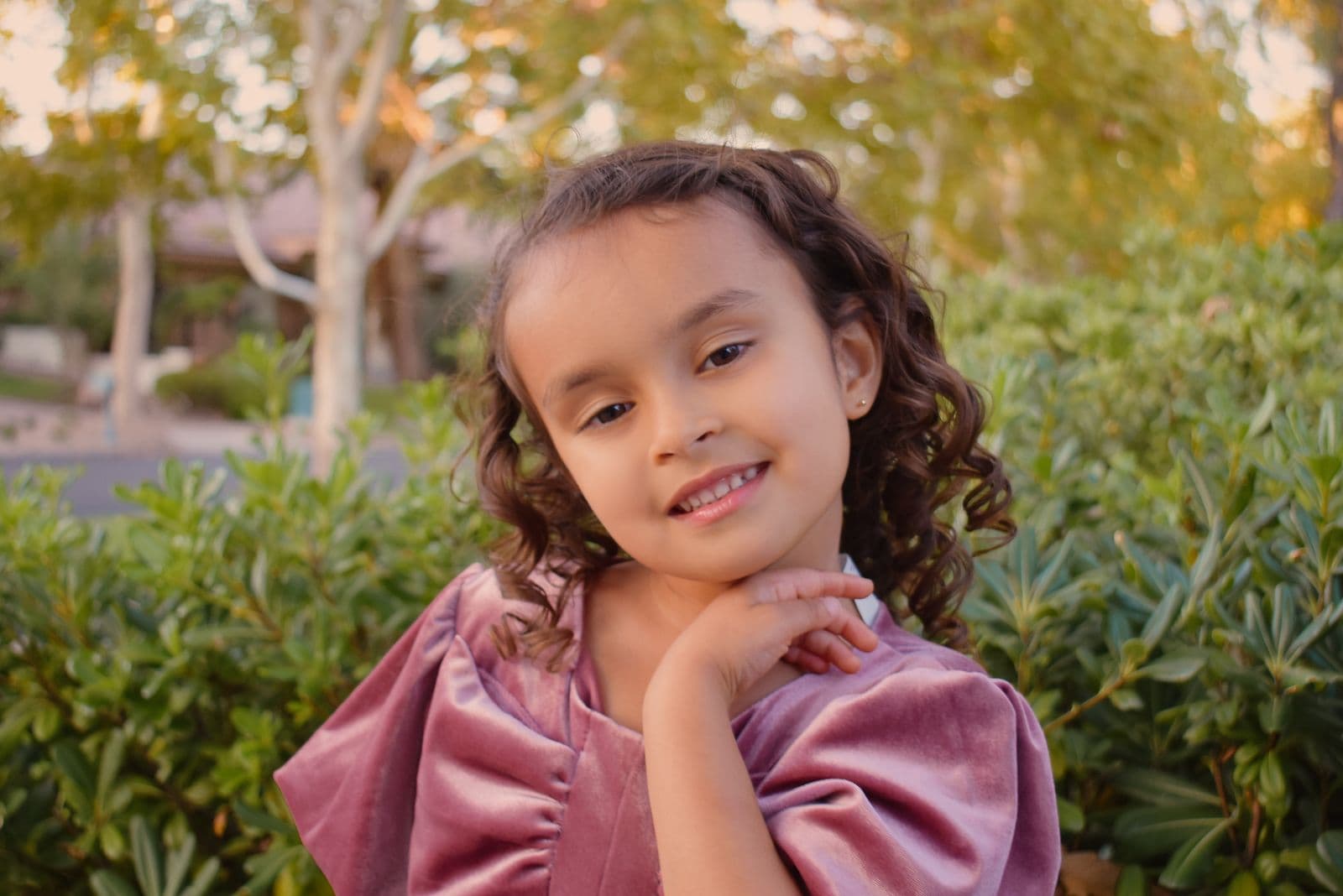 A little girl in a pink velvet dress photographed outdoors during a family session in Las Vegas, NV