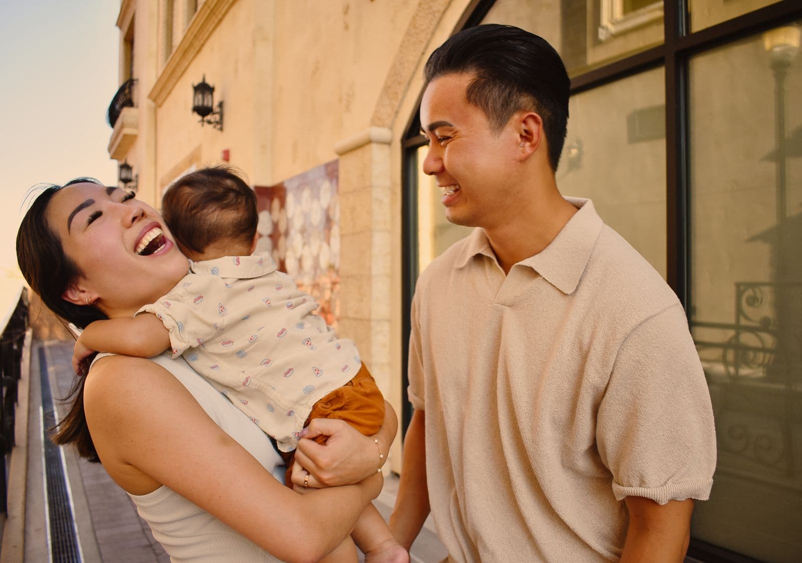 A mother holding her baby while her husband laughs beside her, Las Vegas, NV family session