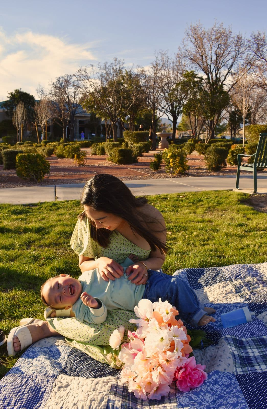 A mother lying back on a picnic blanket with her toddler beside her during a Las Vegas, NV family session