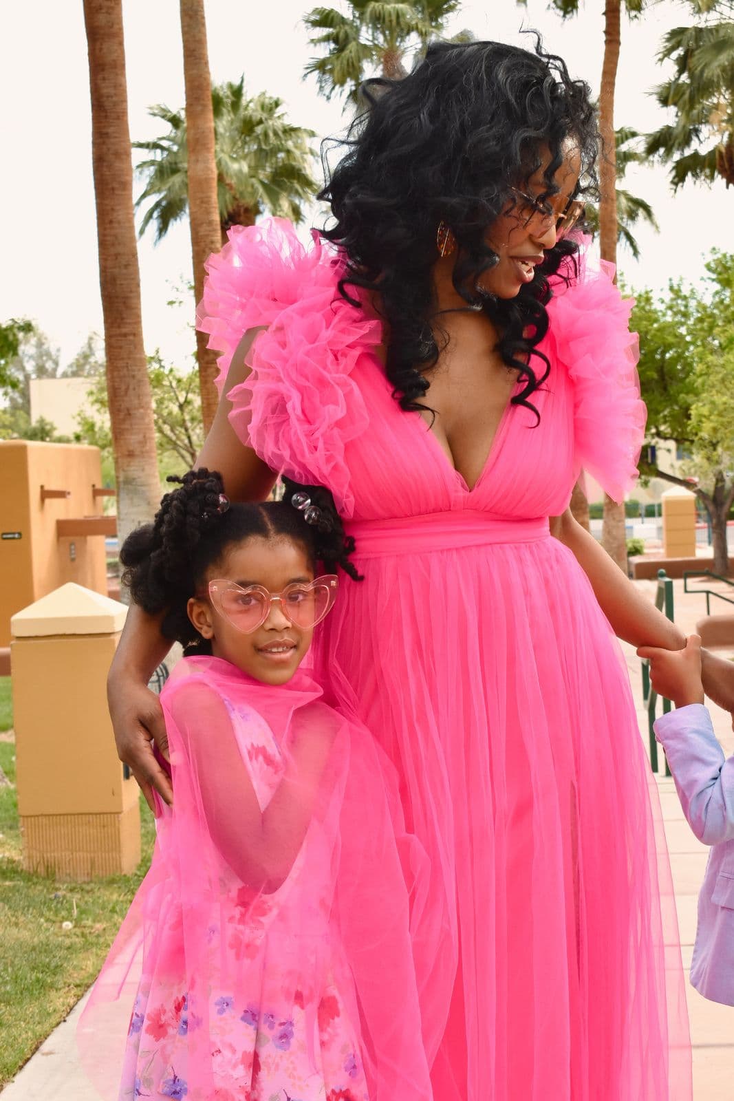 A mother in a pink gown resting her hands on her daughter's shoulders at a Las Vegas, NV park