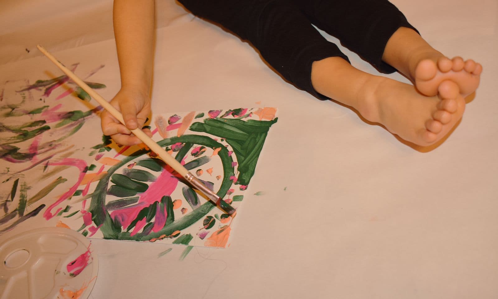 A painted leaf print on paper beside a child's bare foot during an at-home family session, Las Vegas, NV