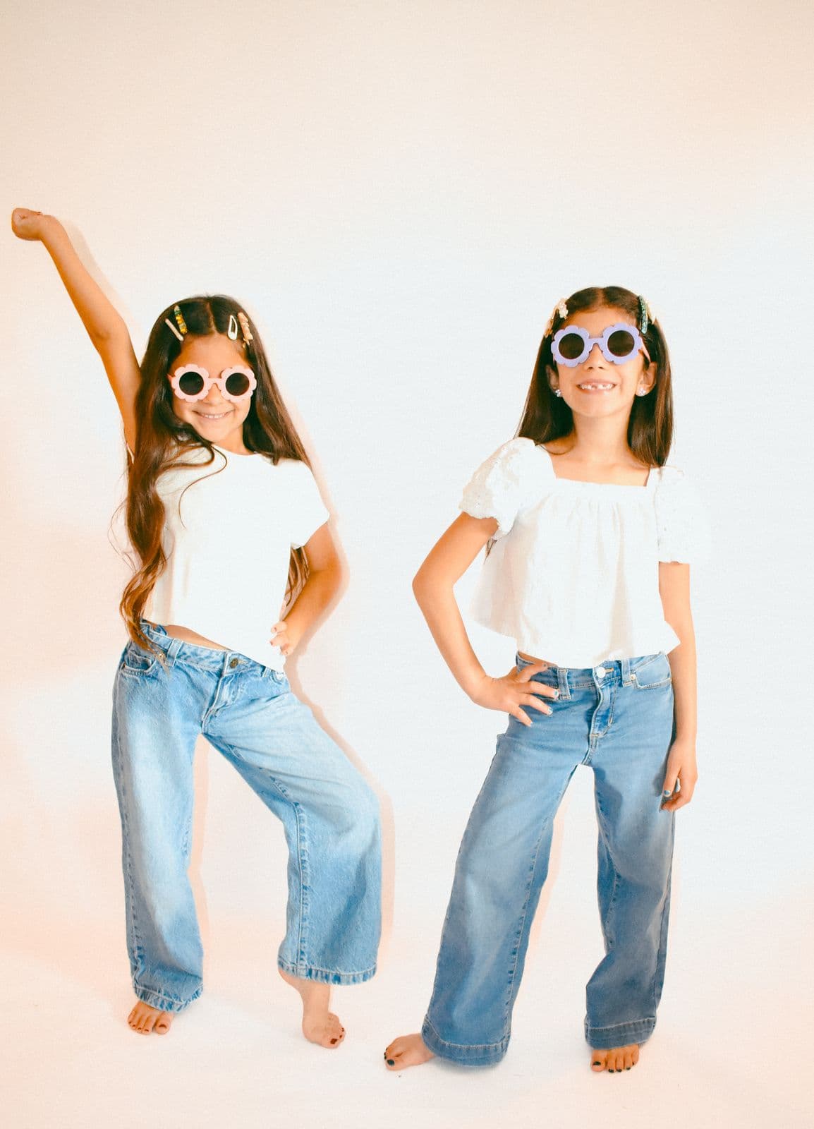 Two sisters standing side by side in jeans and white tops during a Las Vegas, NV studio session