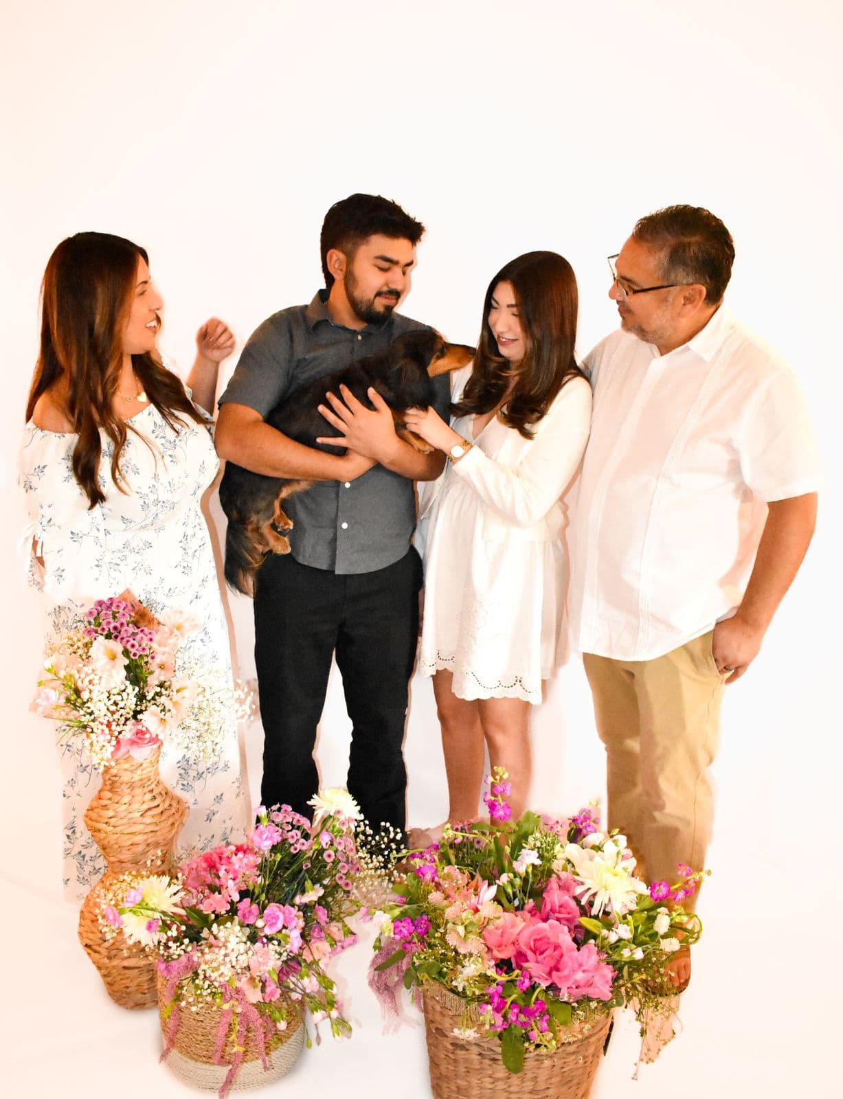 A family of five photographed in studio against a cream backdrop with baskets of spring flowers, Las Vegas, NV