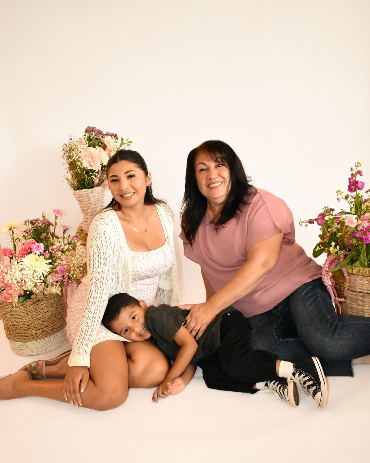 A mother, grandmother and young boy photographed in studio with baskets of flowers in Las Vegas, NV