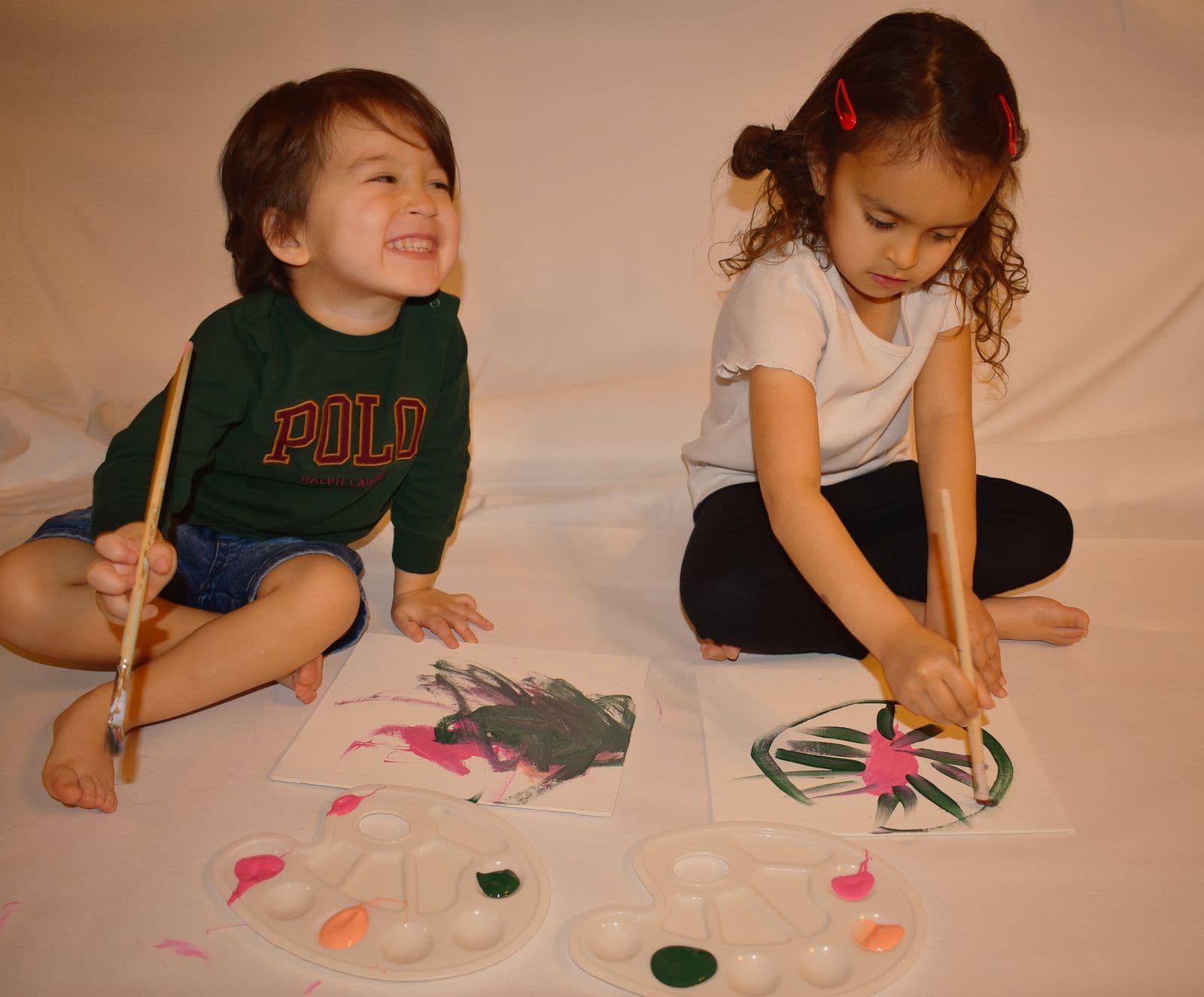 Two children painting side by side on the floor during an at-home family session in Las Vegas, NV