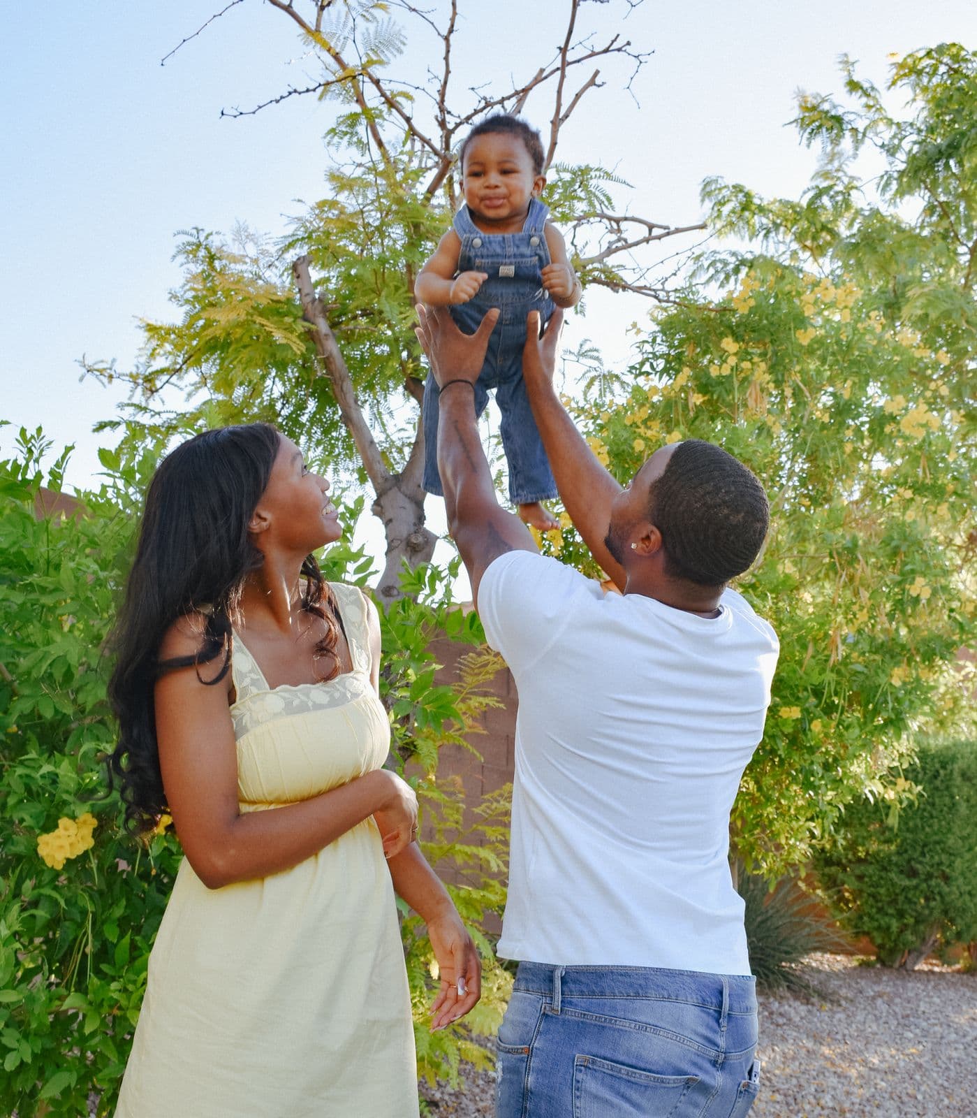 Parents lifting their toddler overhead between them during an outdoor family session in Las Vegas, NV