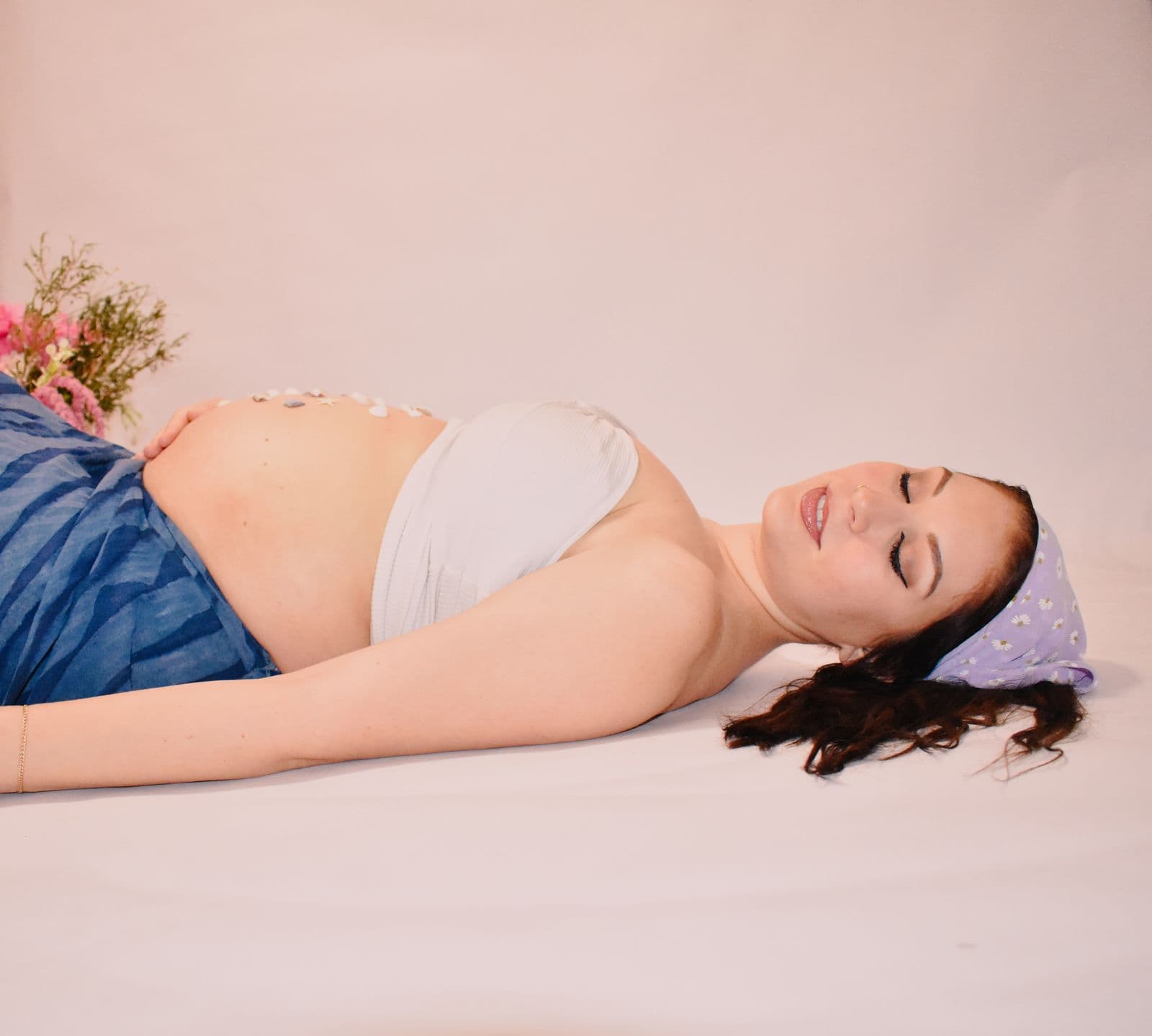 An expecting mother resting with her eyes closed in a floral head scarf during an in-studio maternity session in Las Vegas