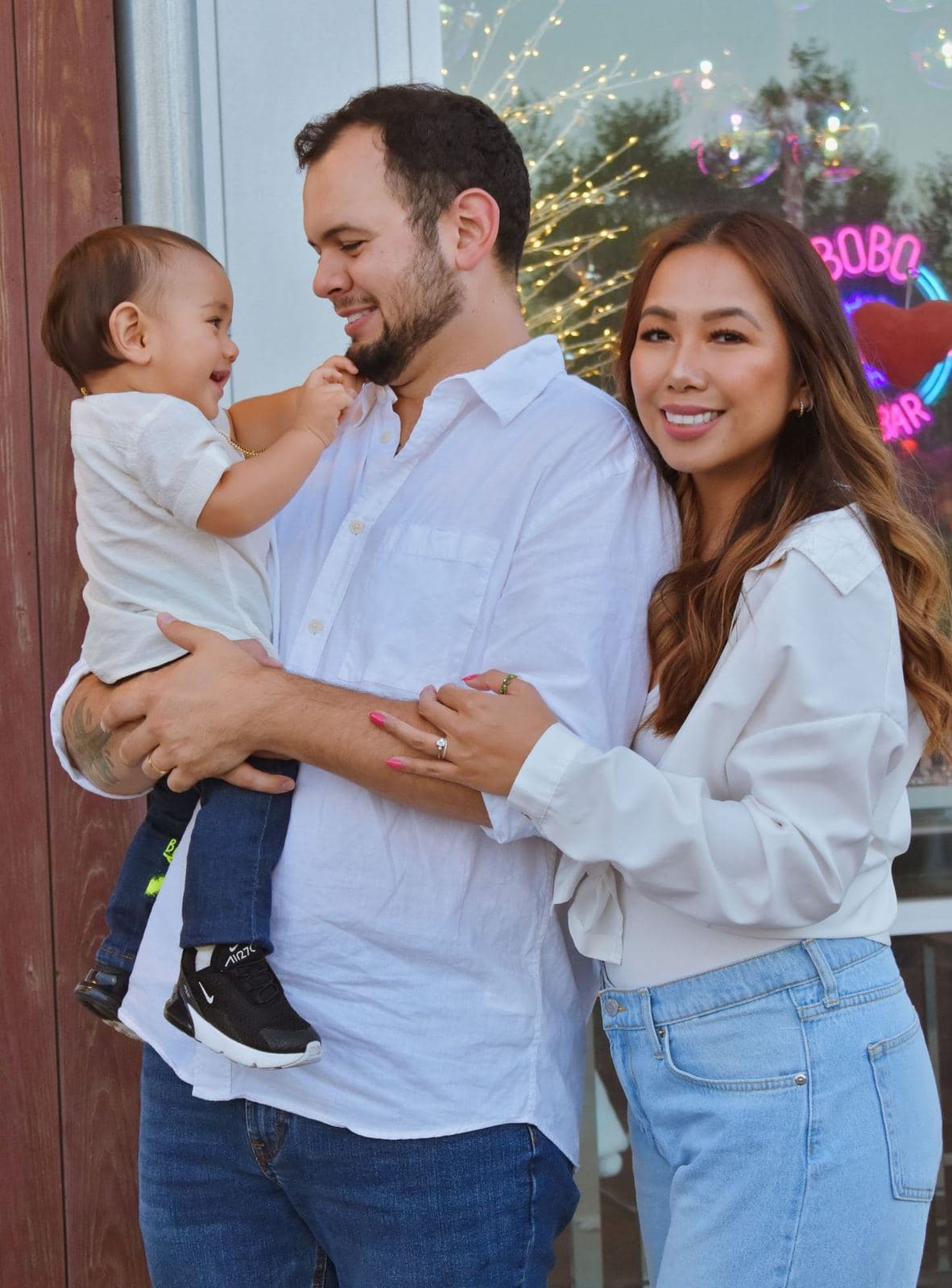 A joyful Las Vegas family moment captured against a backdrop of holiday lights and decorations